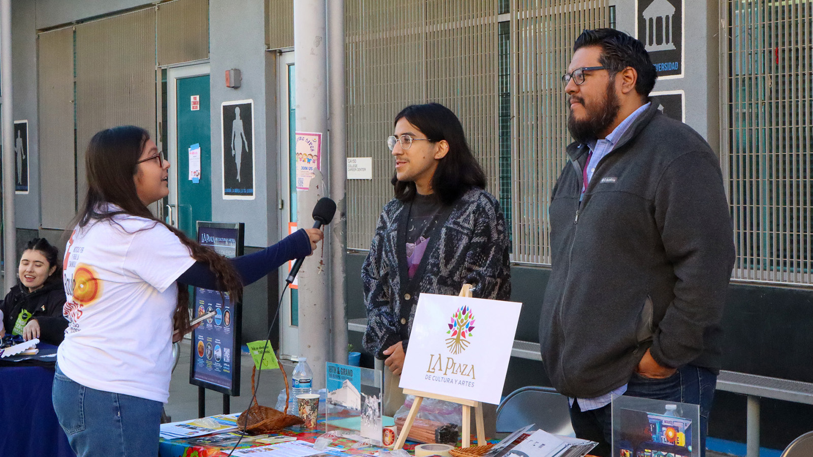 A Boyle Heights Beat youth news reporter conducts interviews before a Candidate Forum Resource Fair. Credit: Andrew Lopez